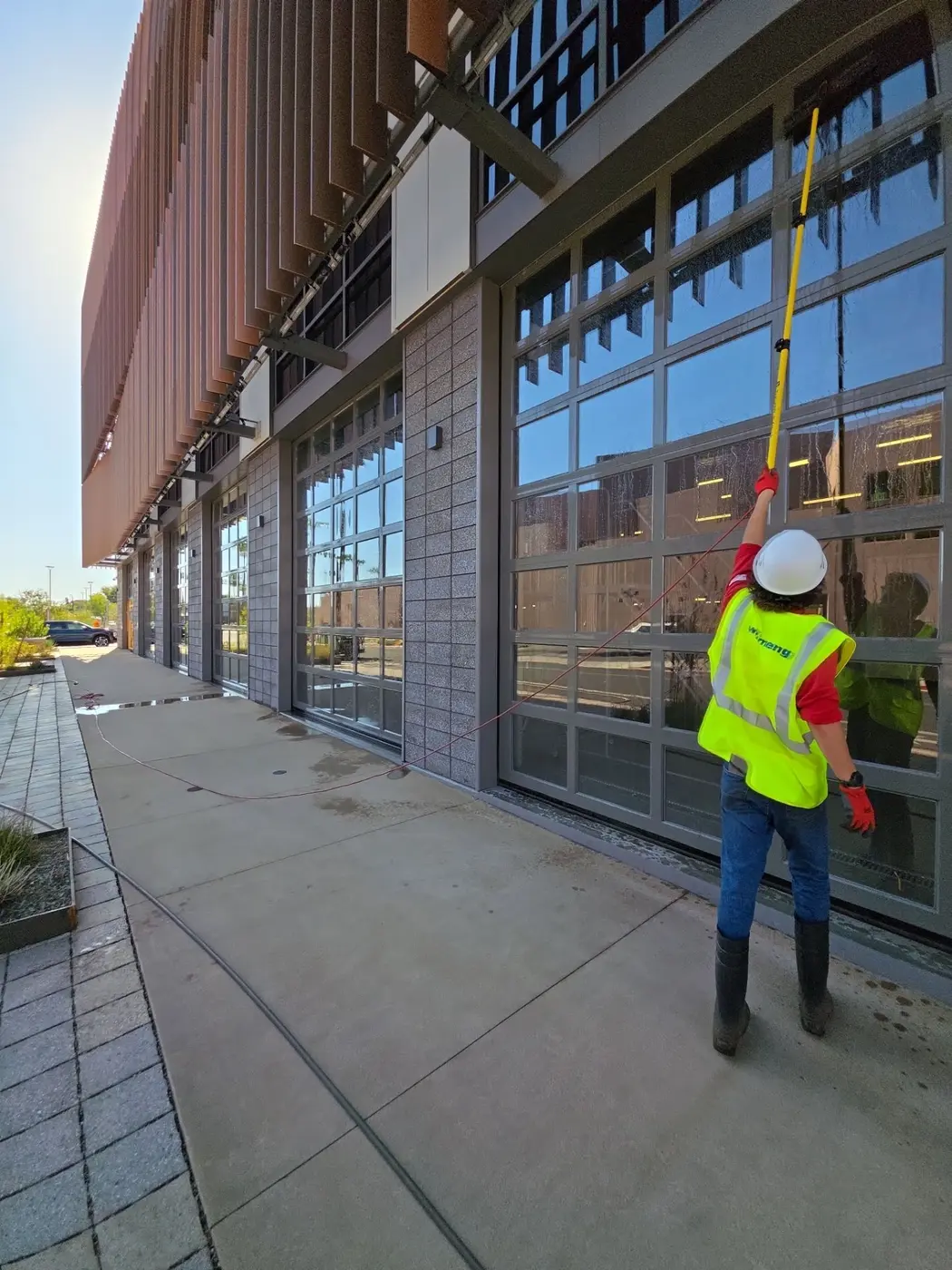 Patriot crew member washing a commercial building exterior