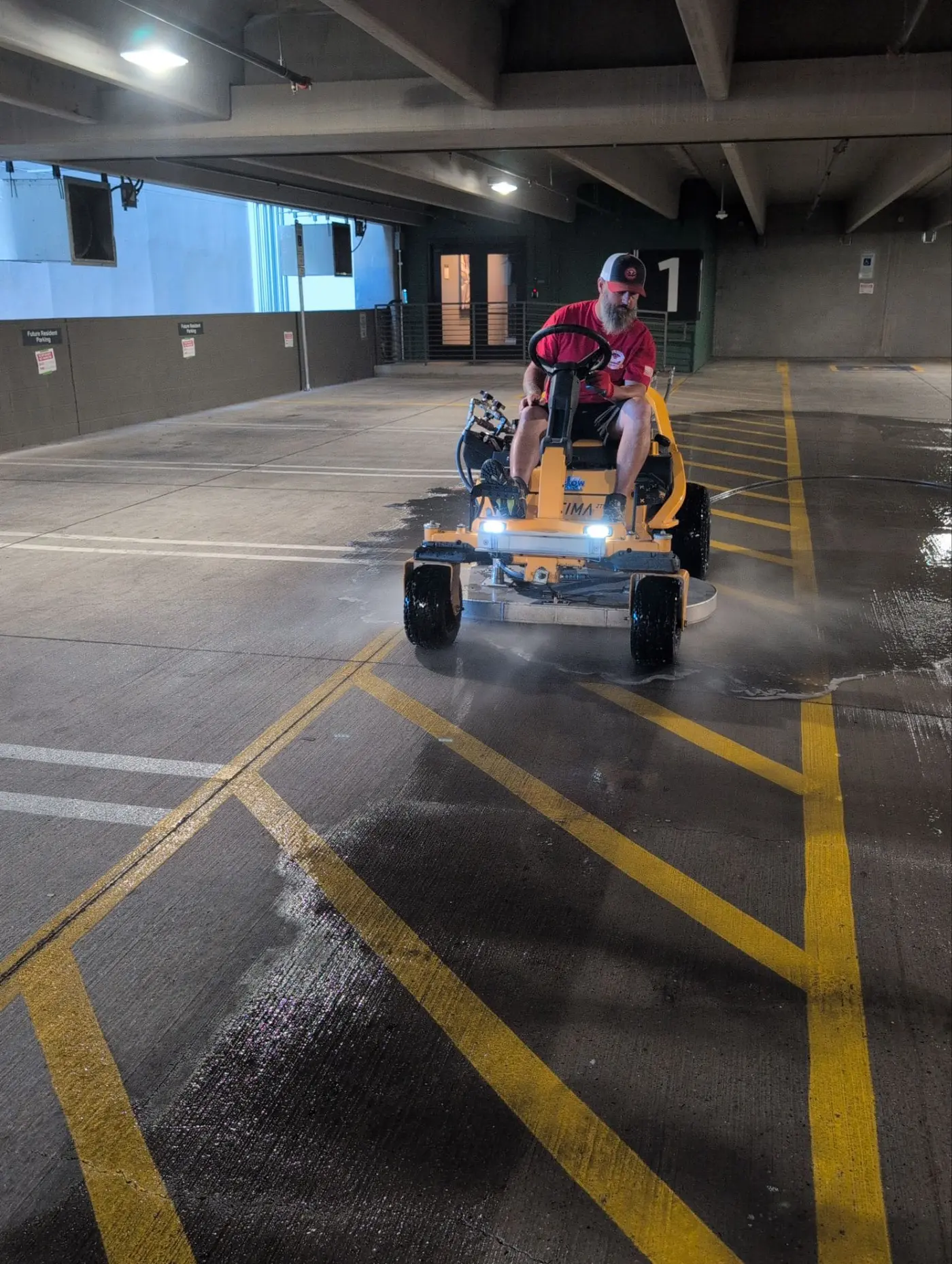 Patriot cleaning the first-floor parking level at Modera Scottsdale with a visible cleaned and uncleaned line